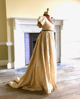 A lady's Regency style day dress in cream silk with black lace trim (lacing at back). Ex London Festival Opera 'Cosi fan tutte'